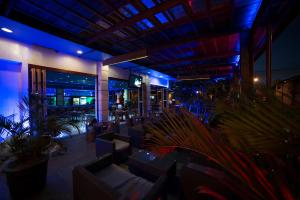 Hotel Elegance NV في باراماريبو: مطعم به طاولات ونباتات في أوعية في الليل