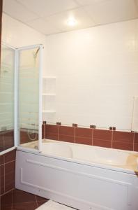 a bathroom with a tub and a glass shower at Apartment Victory Second in Pomorie