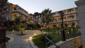 a large building with a pathway in front of it at Adams Hotel in Parga