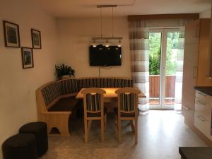 cocina y comedor con mesa y sillas en Appartments Stefania, en Tösens