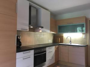 uma cozinha com armários brancos e um aparelho preto em Appartments Stefania em Tösens