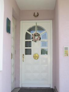 una porta bianca con una corona di Villa Rose a Sankt Kanzian