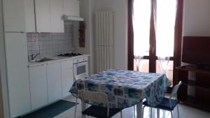 a kitchen with a table and chairs and a kitchen with a table and a counter at casa letizia in Porto Recanati