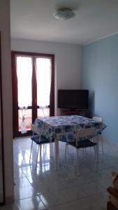 a dining room with a table and two windows at casa letizia in Porto Recanati