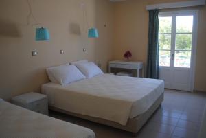 a hotel room with two beds and a window at Apollonia Hotel in Masouri