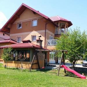 uma casa com um parque infantil em frente em Villa Hills em Sarajevo