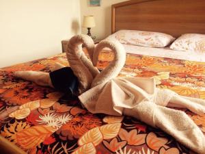 due cigni sdraiati sopra un letto di La Vela Apartment a Stintino