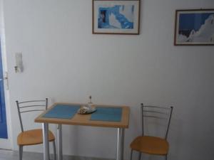 a table with two chairs and a table with a blue placemats at Limani Apartments in Plakias