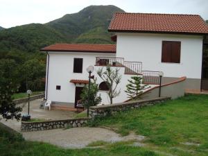 a white house with a staircase in front of a mountain at Agriturismo Costiera Amalfitana in Tramonti