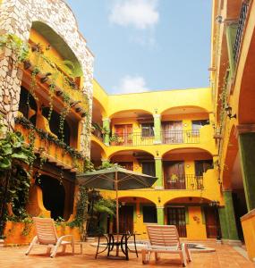 a courtyard with chairs and an umbrella in a building at Hacienda Del Caribe Hotel in Playa del Carmen