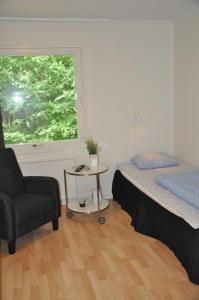 a bedroom with a bed and a chair and a window at Spånhults Herrgård Hostel in Norrahammar