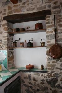 a kitchen with a counter with pots and pans on shelves at La corte di Pietro in Isnello