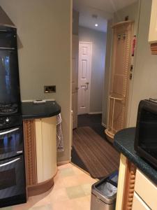 a kitchen with a counter and a hallway with a door at Rooms at Tarrareoch in Bathgate