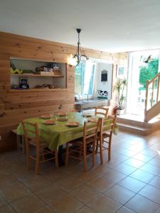 a dining room with a green table and chairs at Gite Mentrel in Champ-le-Duc