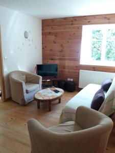 a living room with a couch and chairs and a table at Gite Mentrel in Champ-le-Duc