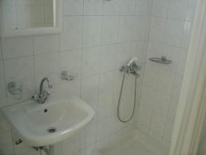 a white bathroom with a sink and a shower at Bali Studios - Marinakis in Balíon