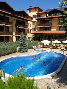 a group of people swimming in a swimming pool at Hotel Center in Apriltsi