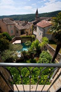 - un balcon avec vue sur une ville et une piscine dans l'établissement Le Castellas Hotel & SPA - TERITORIA, à Collias