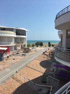 a balcony of a building with tables and chairs at Apartament First Line in Karolino-Buhaz