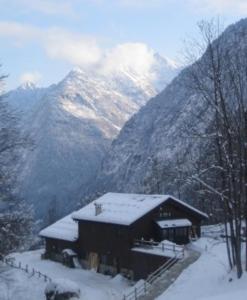 un edificio con nieve delante de una montaña en Agriturismo Alagna, en Alagna Valsesia