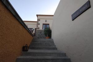 Una escalera que conduce a un edificio con un cartel. en Casa Rural El Roque en Taibique