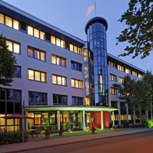 einem externen Blick auf ein Gebäude mit einem Uhrturm in der Unterkunft Hotel Carat in Erfurt