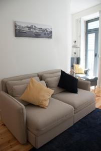 a living room with a couch with pillows on it at OportoView Alegria Apartment in Porto