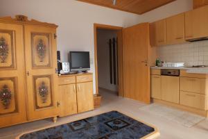 a kitchen with wooden cabinets and a tv on a counter at Haus Schneeflocke in Lech am Arlberg