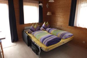 a bed in a wooden room with pillows on it at Haus Schneeflocke in Lech am Arlberg