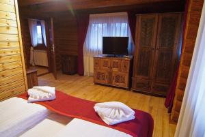 a room with a bed and a tv in a room at Honor Pensiune & Spa in Izvoare