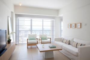a living room with a white couch and a table at Sandy Beach Hotel & Spa - ex Sentido in Larnaca