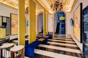 a hallway with yellow columns and blue seats in a building at Hotel INN Rossio in Lisbon