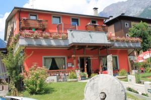 a red building with a sign on the front of it at Jolly Residence in Bormio