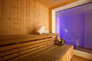 a wooden sauna with a bench in a room at Sandy Beach Hotel & Spa - ex Sentido in Larnaca