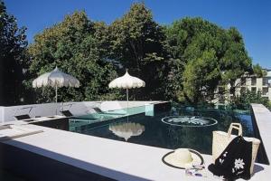 - une piscine avec deux parasols dans l'établissement M Glamour Hotel, à Gabicce Mare