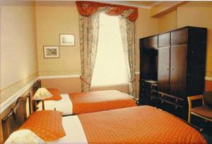 um quarto de hotel com duas camas e uma janela em Murrayfield Park Guest House em Edinburgo