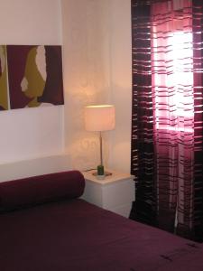 1 dormitorio con cama y lámpara junto a una ventana en T2 House @ Consolação Peniche, en Consolacao