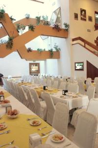 un salón de banquetes con mesas blancas y sillas blancas en Hotel Enriquez, en Coatzacoalcos