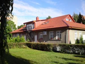 a house with a red roof and a yard at Klaipeda INN Private Parking and Kitchen in Klaipėda