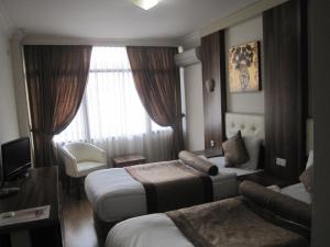 a hotel room with two beds and a window at Alican 1 Hotel in İzmir
