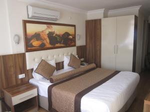 a bedroom with a bed and a painting on the wall at Alican 1 Hotel in Izmir