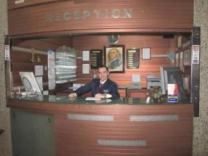 a man sitting at a counter in a dispatcher at Alican 1 Hotel in Izmir