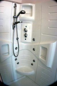 uma casa de banho com um chuveiro e um lavatório. em Hotel Sacramora em Rimini