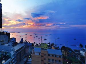 a view of the ocean from a city at sunset at Sunbeam Hotel Pattaya - SHA Extra Plus in Pattaya Central