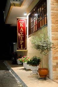 a sign on the side of a building with potted plants at Hotel Kastri in Loutra Edipsou