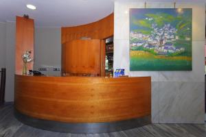 eine Holztheke in einem Raum mit einem Gemälde an der Wand in der Unterkunft Hotel Vetusta in Oviedo