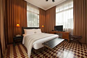 a bedroom with a large bed and a television at The Henry Hotel Manila in Manila