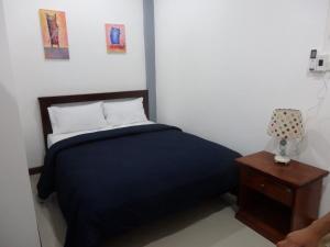 a bedroom with a bed and a nightstand with a black blanket at Anong's 2 bedroom family home for up to 6 guests in Ko Samed