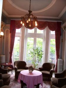 a living room with a table and a large window at Hotel Manhattan in Brussels