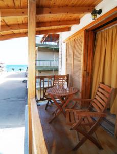 a patio with a table and chairs on a balcony at Studios Maria in Paralio Astros